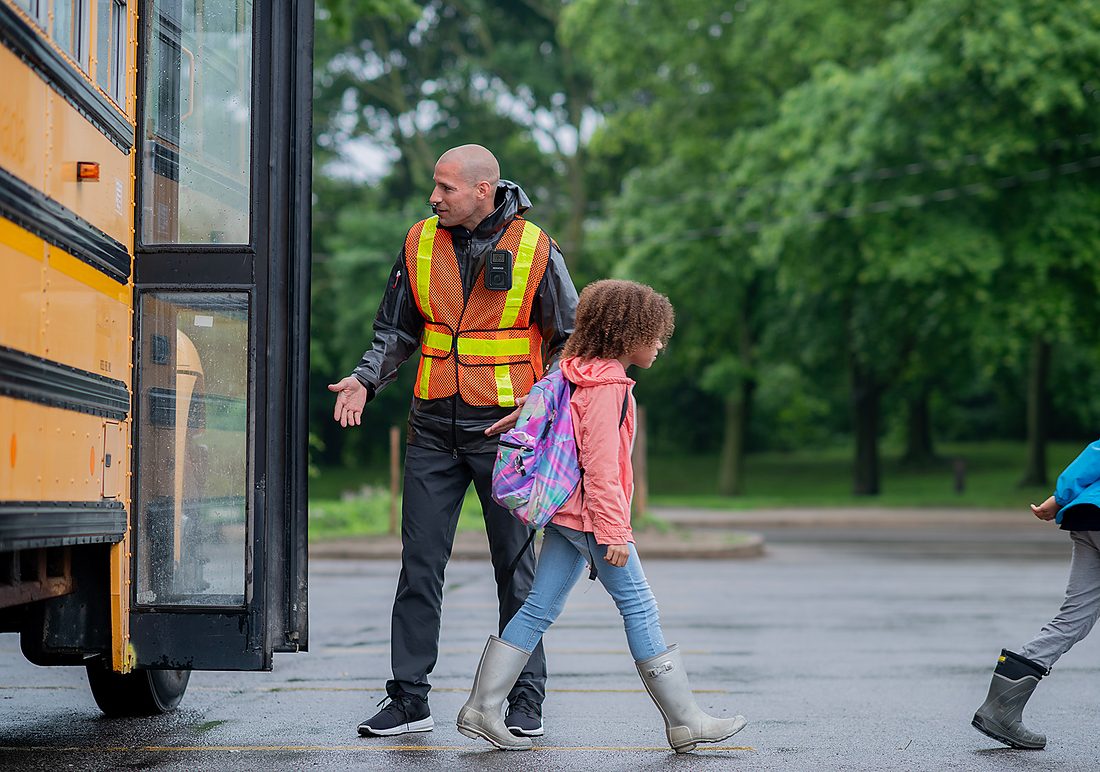 School staff member wearing a KENWOOD body camera at bus dismissal